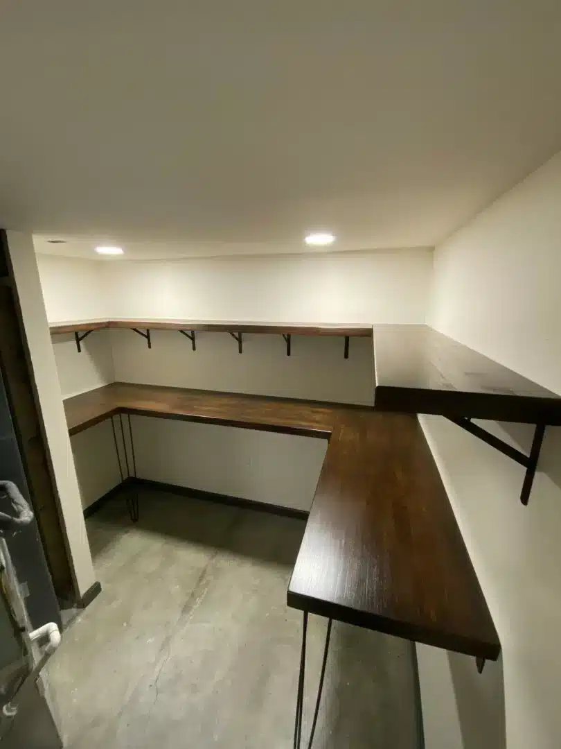 Basement storage room with a custom wood countertop and coat hooks